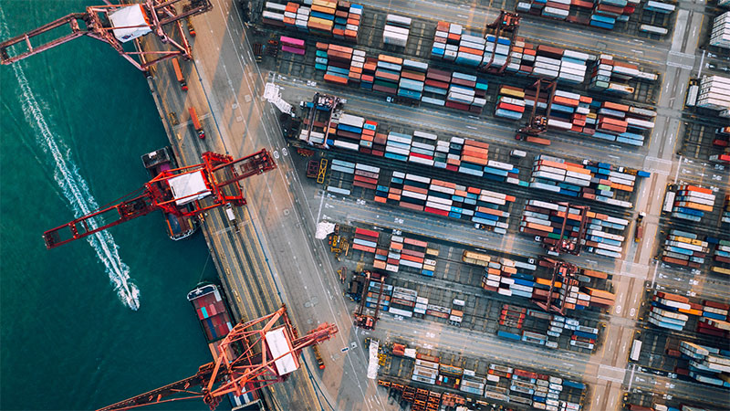 Aerial view of container port – parametric insurance could protect supply chains from costly shipping delays.